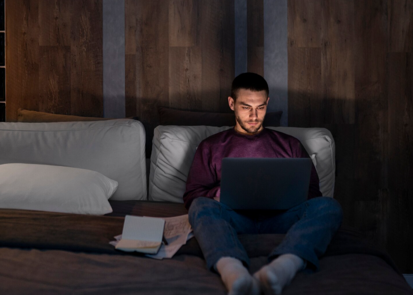 Late night search effect as someone searches online alone in a dark bedroom